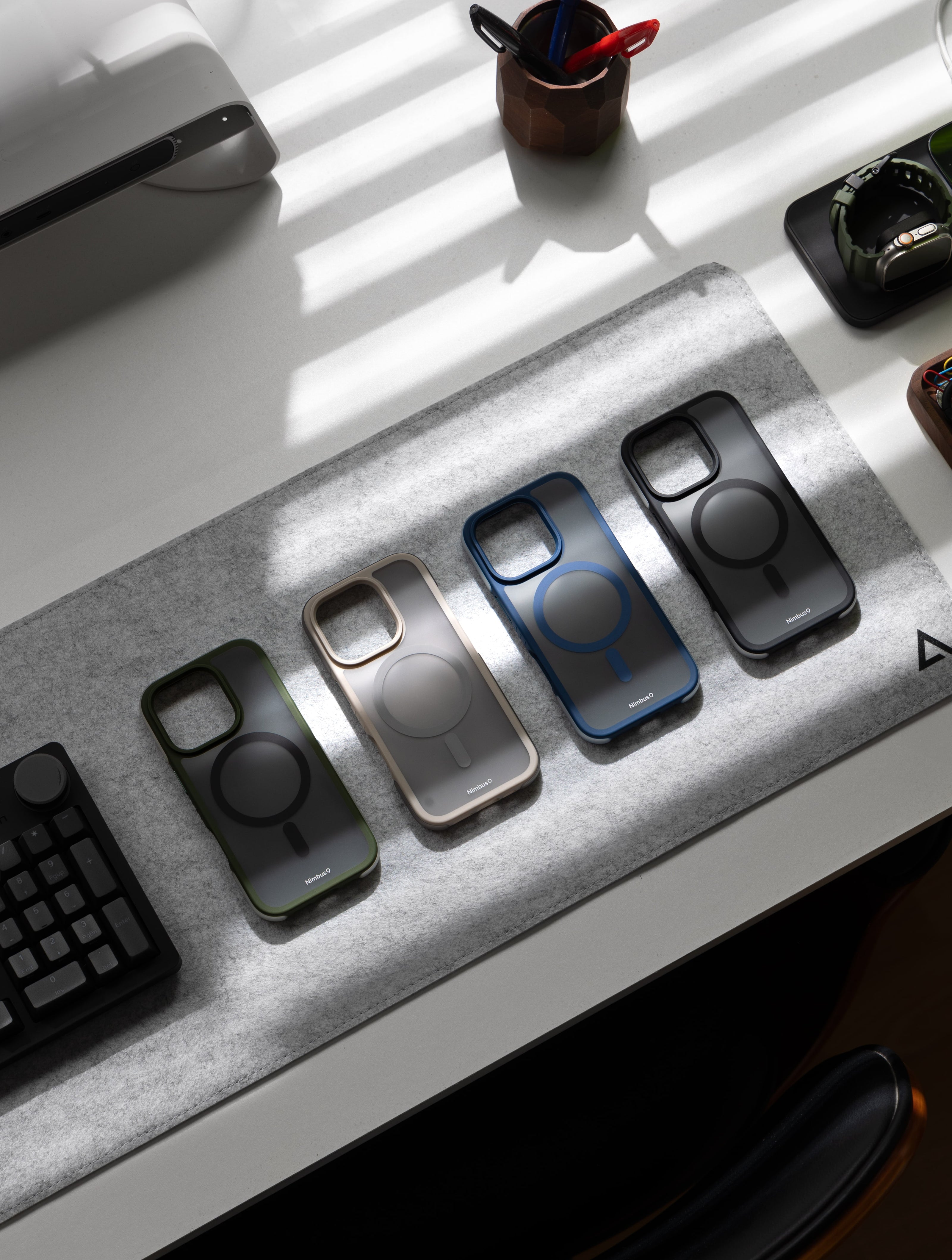 A premium selection of Nimbus9 Summit MagSafe cases displayed on a sleek workspace, showcasing their rugged protection, modern design, and MagSafe compatibility. Available in Green, Gold, Blue, and Black, the Summit case is built for durability and style. Perfect for iPhone users seeking ultimate protection with a sophisticated touch.
