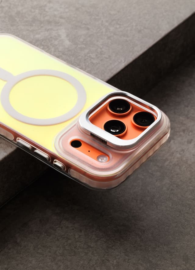 Macro of a Stratus 2 case's edge on gray marble, translucent button caps and camera ring in frame