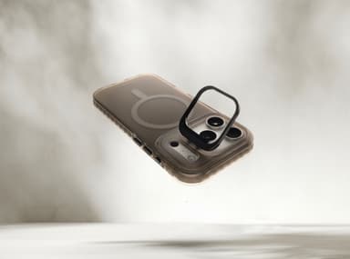 Stratus 2 case in Smoke floating over a pale haze, its integrated kickstand ring flipped open around the camera module, MagSafe ring visible