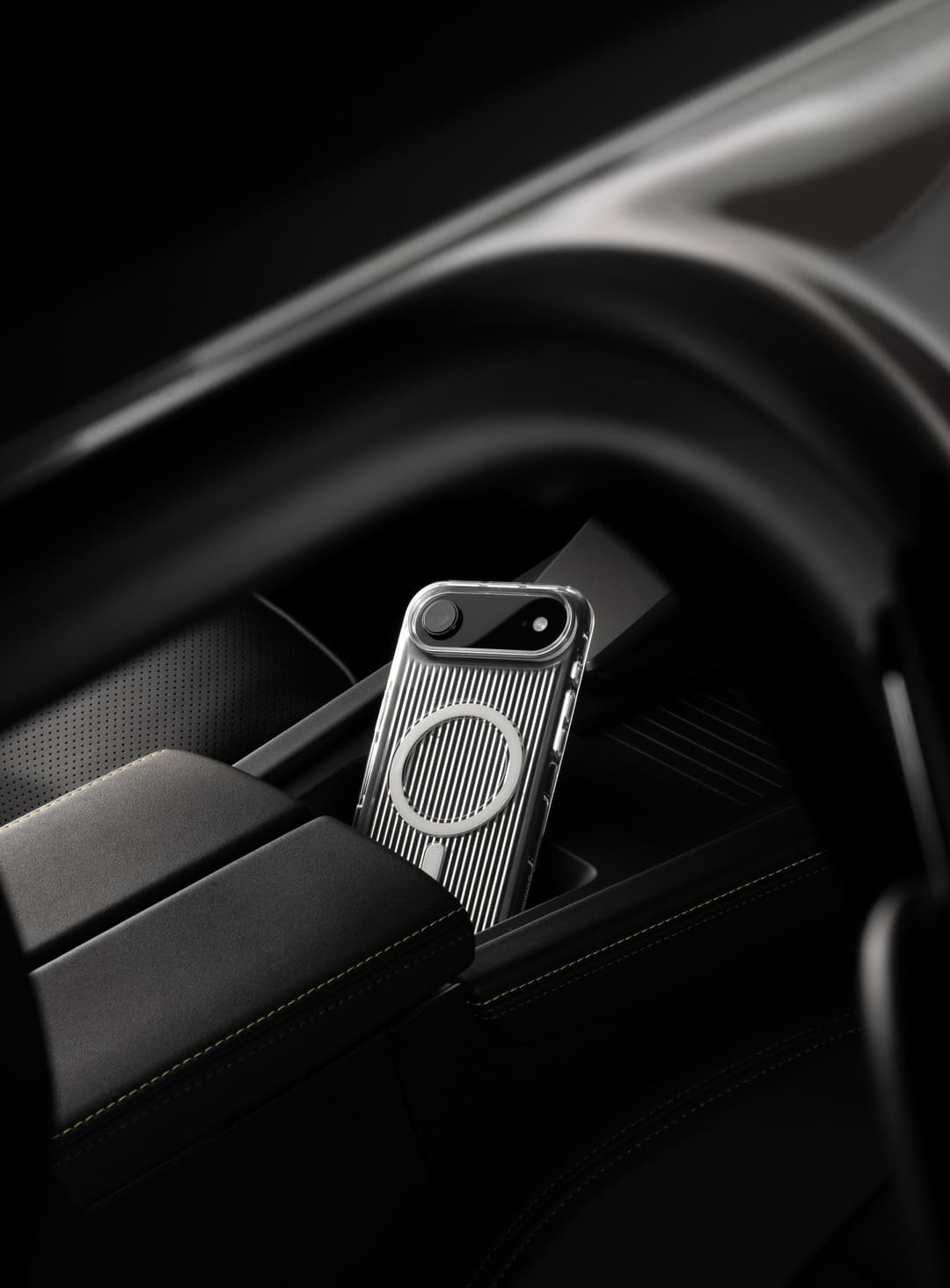 Nimbus9 clear ribbed MagSafe case on iPhone, propped in a car center console cupholder